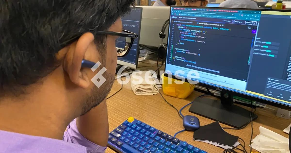 A man is using a computer while wearing a headset, indicating he is involved in a work-related activity or communication